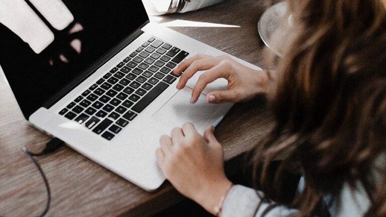 student writing on laptop